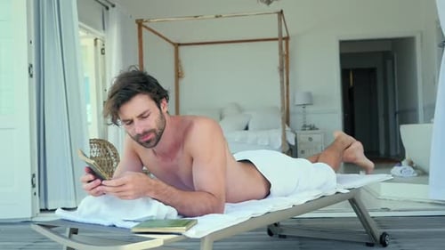 Man Relaxes on Lounge Chair Reading a Book