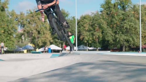 Young Adult Performing BMX Bike Tricks in Skatepark