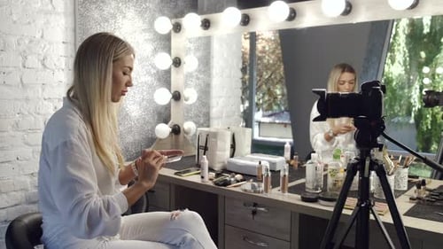 Una maquilladora está haciendo su tutorial de maquillaje ante la cámara