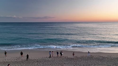 People sit on the beach and watch the sunset