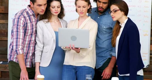 Five Adults Looking at a Laptop in an Office