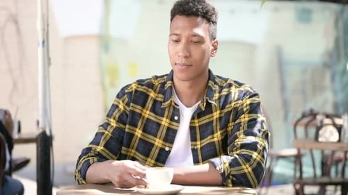 Relaxing Young African Man Drinking Coffee, Outdoor Cafe