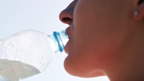 Handheld view of woman taking a sip of water. Shot with RED helium camera in 8K