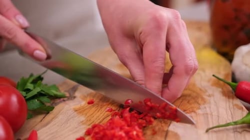 Woman Chopping Fresh Chili Pepper on Cutting Board