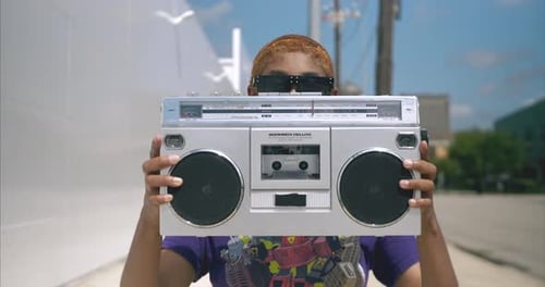Toma mediana de una joven atractiva escuchando música en el boom box