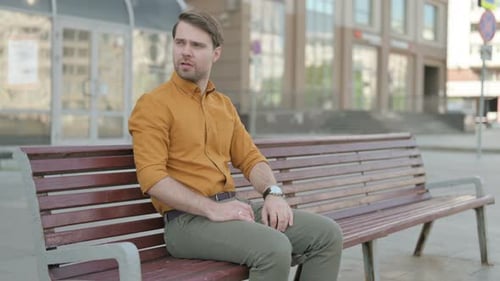 Man Sitting on Bench Checking the Time