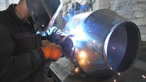 Schweißer, der die Verbindung zwischen zwei Stahldetails herstellt