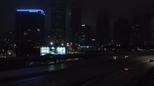 Ascending Drone View Reveal Low Traffic on Highway and City Lights in Downtown at Night