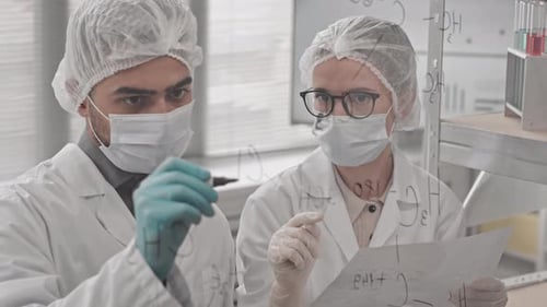 Chemists Writing Structural Formulas on Glass