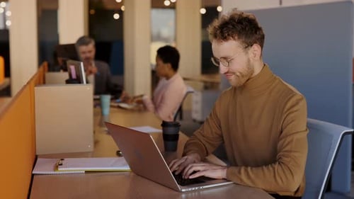 Young Adult Working on Laptop in Modern Office