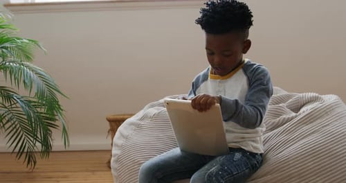 Boy using tablet computer at home