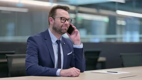 Man in Suit Talking on Phone in Conference Room