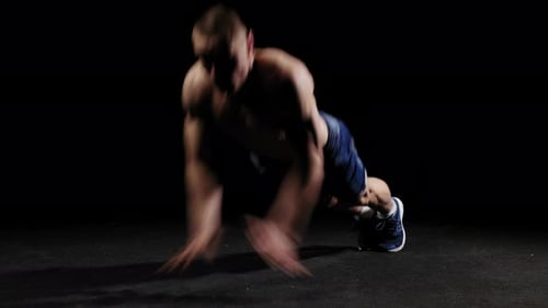 Young Pumped Man Trains in the Arena Warming Up with Push Ups