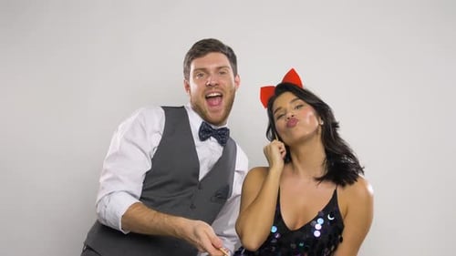 Couple with Party Props Having Fun and Posing