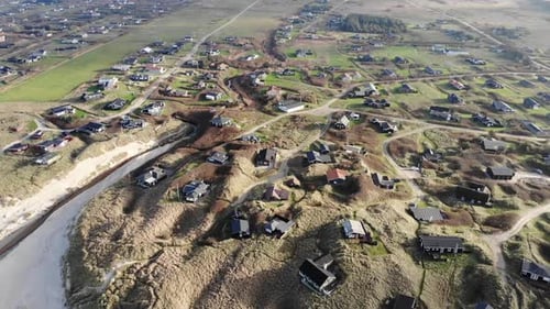 Luftaufnahme der Nordseeküste außerhalb von Løkken, Dänemark, mit Hütten in den Dünen