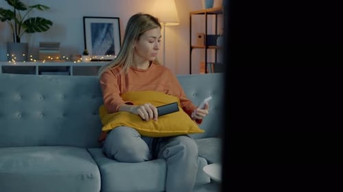 Woman Using Phone on Couch in Cozy Living Room