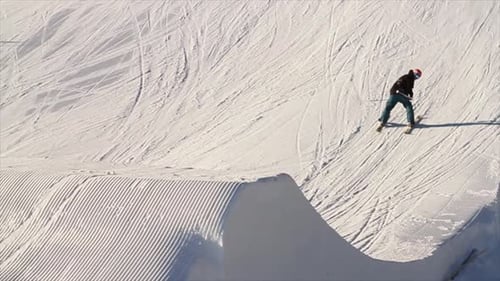 Ein Mann fährt im Winter einen schneebedeckten Berg hinunter