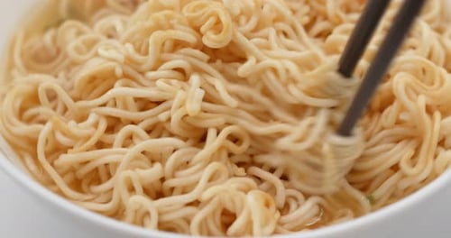 Close Up of Noodles Stirred with Chopsticks