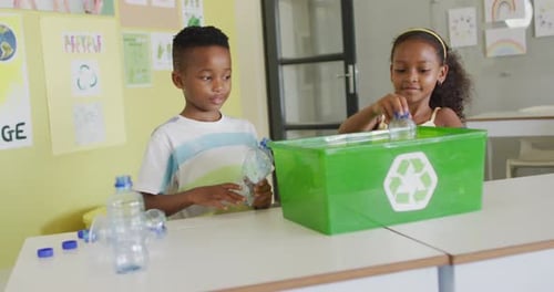 Students Recycling Plastic Bottles in Classroom Recycle Bin