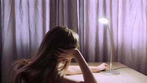 Young Woman Sitting at Desk at Night