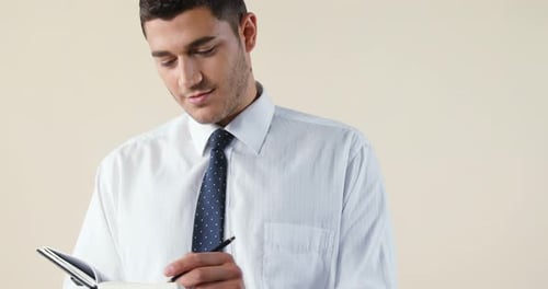 Young Adult Writing in Notebook with Pen