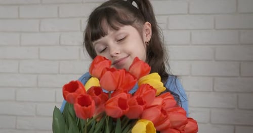Happy Girl Holding a Bouquet of Tulips