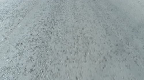 Drone Flying Above Asphalt Mountain Road Following White Mid Line. Tree Shadows on the Road.