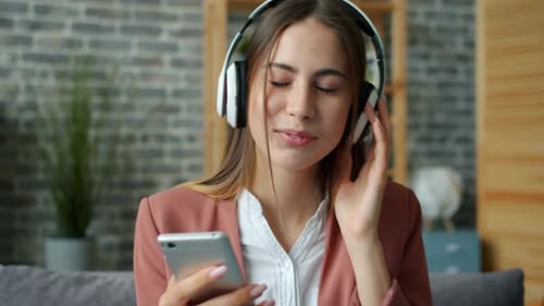 Woman Listening to Music at Home on Smartphone