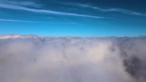 Aerial View From High Altitude of Earth Covered with White Puffy Cumulus Clouds on Sunny Day