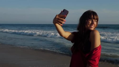 Attractive woman taking a selfie at the beach