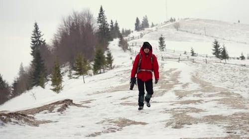 Solo Hiker Walks Snowy Mountain Path in Winter