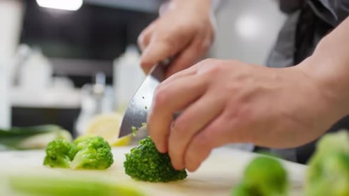 Chef Dices Fresh Green Broccoli with Knife