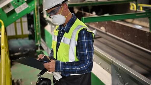Worker Inspecting Recycling Plant Refuse Conveyor Belt