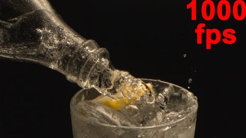 Pouring Refreshing Drink into Glass with Lemon