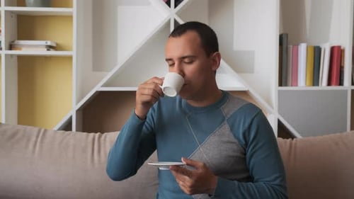 Man Drinking Coffee on Couch Indoors