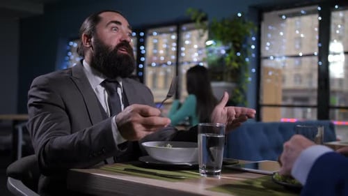 Bearded Man Eating Salad in Restaurant