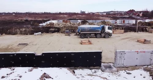 Mit Schmutz und Erde beladener LKW fährt auf einer Baustelle eines Straßenbaukomplexes
