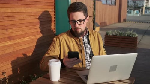 Adult Chilling with Gadgets Outdoor of Cafe.