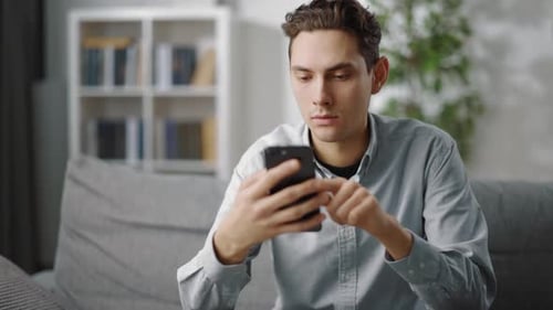 Man Using Smartphone Device at Home on Couch