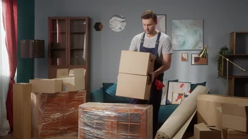 Un reparador está preparando la construcción de muebles en un apartamento, colocando cajas y equipos