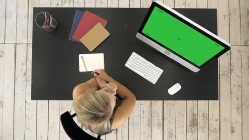 Girl watching on screen of computer. Green Screen Mock-up Display.