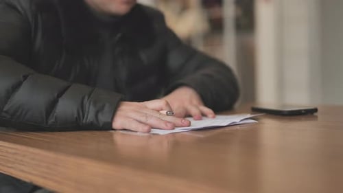 A Man's Hands Work with Documents