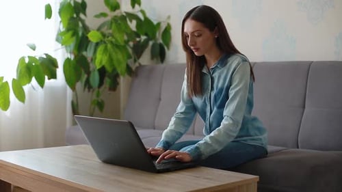 Young Adult Woman Using Laptop at Home