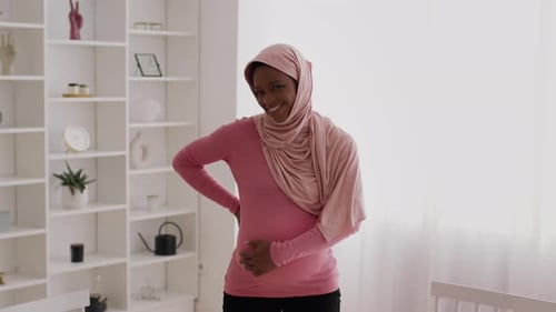 Glowing Pregnant Woman Smiles in Bright Room