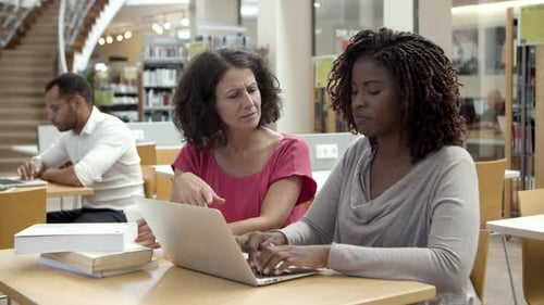 Pensive Students Working Over Project at Library