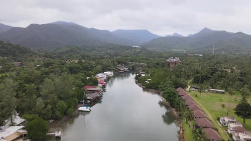 Aerial view of river and mountainous scenery, tilt up reveal shot