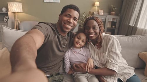 Family Smiling and Waving on the Couch