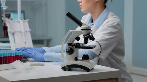 Close Up of Microscope Tool While Scientist Analyzing Petri Dish