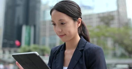 Woman Using Tablet in a City Setting