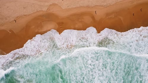 Aerial Top Down View of Waves Rolling Towards Beautiful Sandy Beach